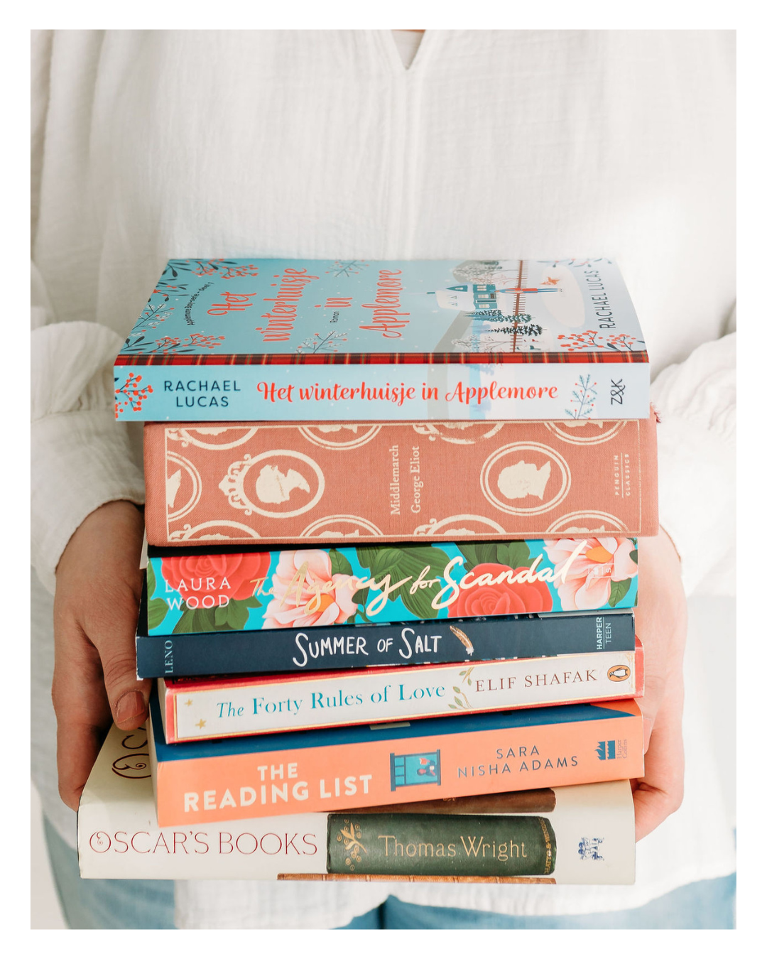 Rosanne van Cruijningen, redacteur en schrijfcoach voor romanschrijvers, houdt een stapel vast met boeken in het Nederlands en Engels – passend bij het blog over Engelse boeken lezen.