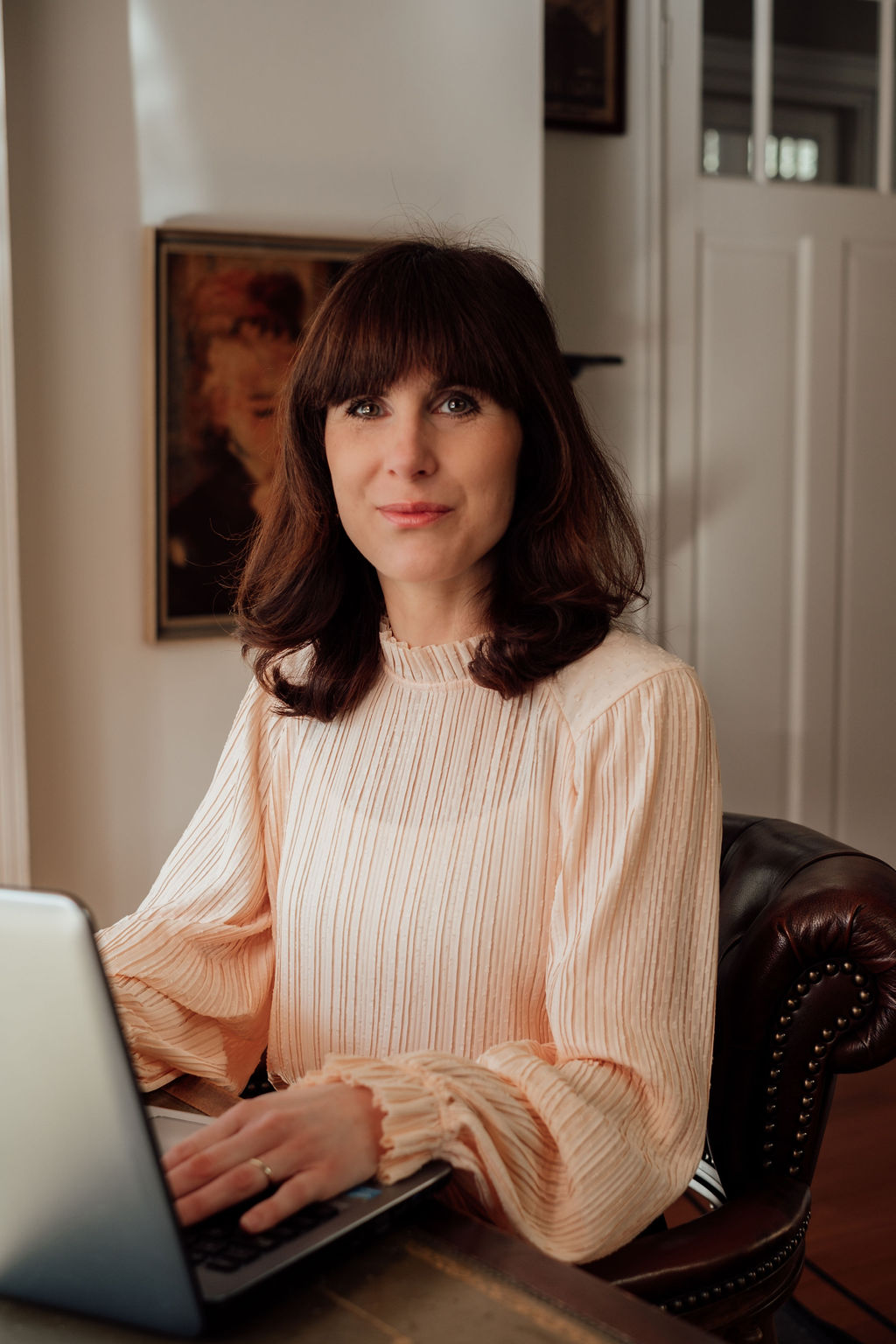 Auteur Floortje Stroeve-Vink achter haar bureau.