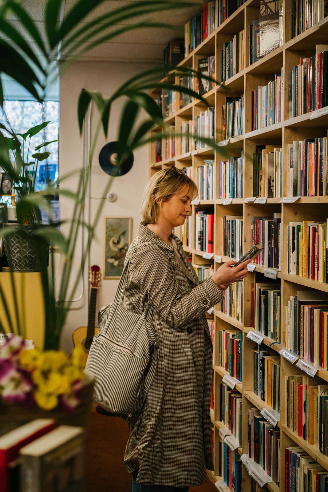 Redacteur Rosanne Sarah bladerend door een boek in een boekwinkel