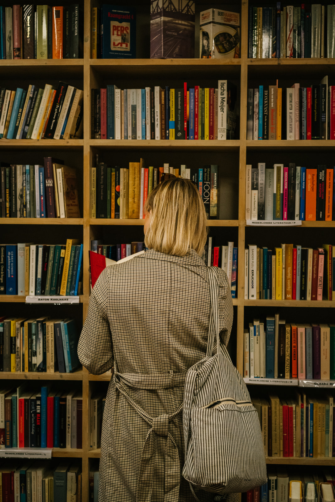 Rosanne van Cruijningen, schrijfcoach en redacteur voor schrijvers van fictie, staat voor een boekenkast.